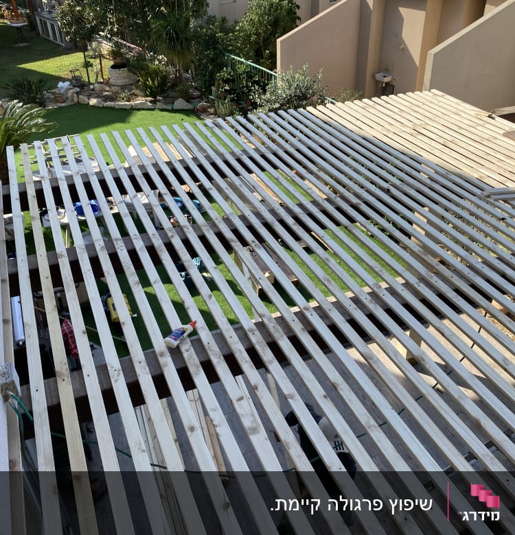 מבנה עץ בבנייה עם כלים וחומרים על הקרקע